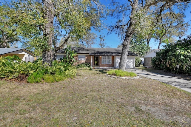 view of front facade featuring a garage, a front yard, concrete driveway, and brick siding