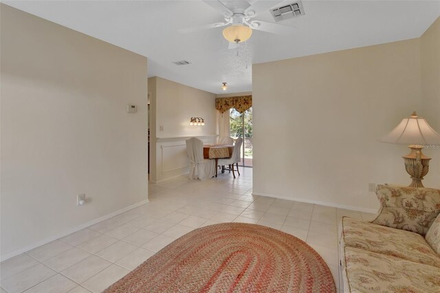 living room with light tile patterned floors, baseboards, visible vents, and a ceiling fan