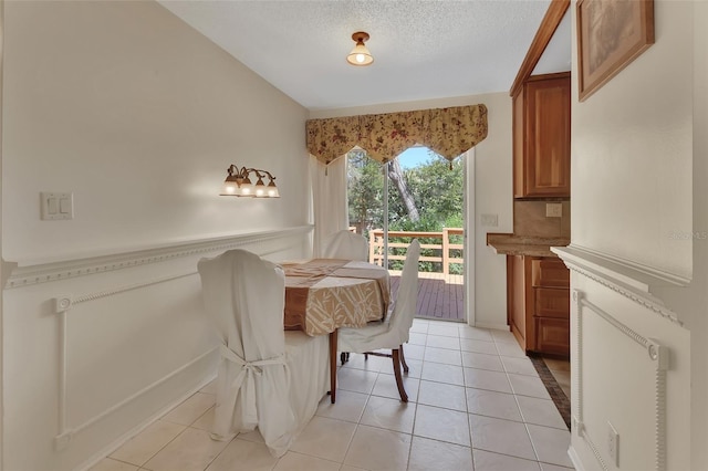 dining room with a textured ceiling and light tile patterned flooring