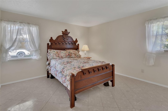 bedroom featuring light tile patterned floors and baseboards