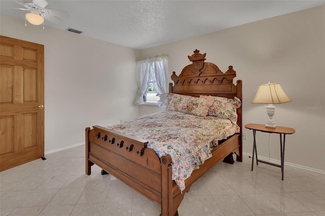 bedroom featuring light tile patterned floors, a textured ceiling, visible vents, and baseboards