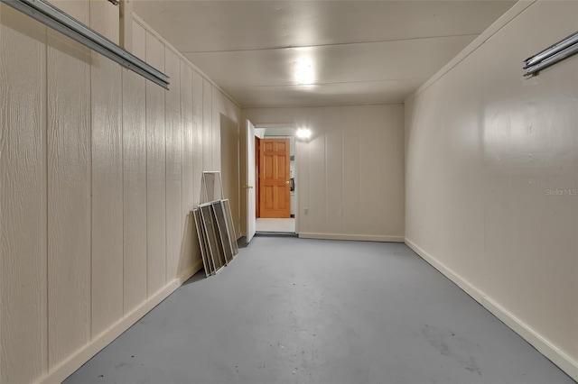 unfurnished room featuring concrete flooring and baseboards