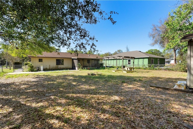 back of property with fence and a lawn