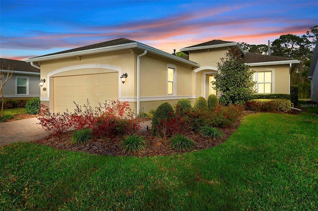 view of front of house featuring a garage, a front yard, and stucco siding