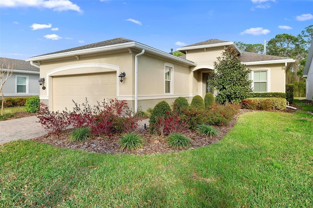 view of front of house featuring a garage, a front lawn, decorative driveway, and stucco siding