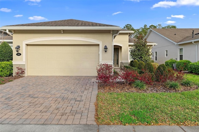 view of front of home with a garage, a shingled roof, decorative driveway, and stucco siding