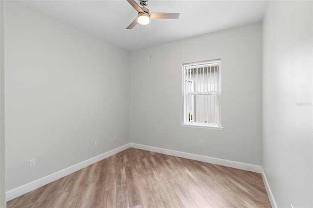 spare room with ceiling fan, light wood finished floors, and baseboards