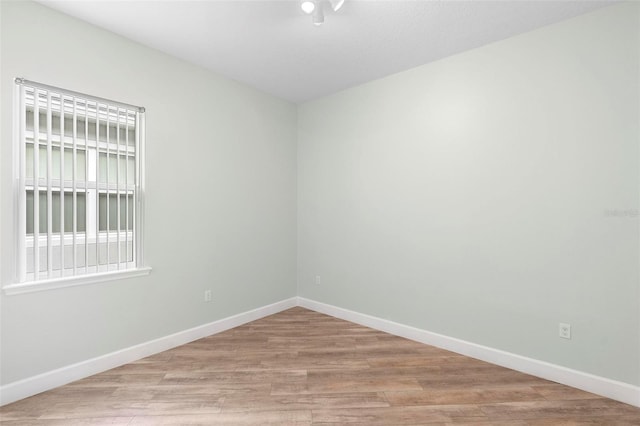 unfurnished room featuring light wood-style flooring and baseboards