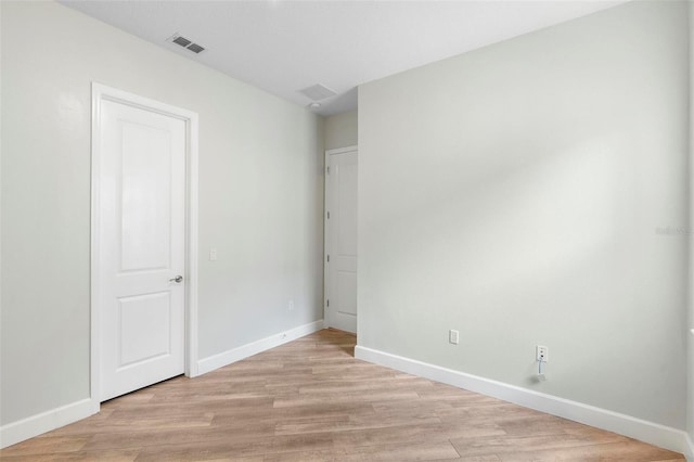 unfurnished bedroom featuring baseboards, visible vents, and light wood finished floors