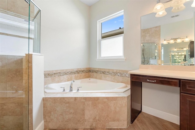 bathroom with visible vents, a stall shower, vanity, wood finished floors, and a bath