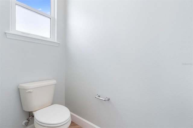 bathroom with baseboards and toilet