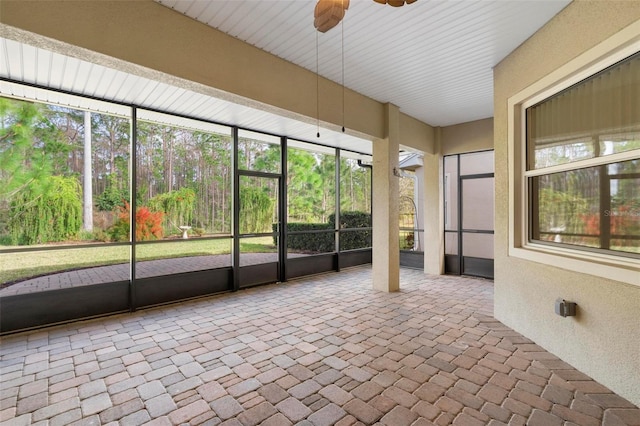 unfurnished sunroom featuring ceiling fan