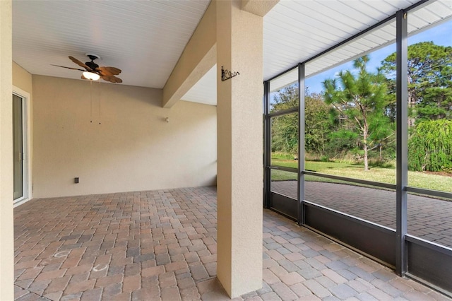 unfurnished sunroom with a ceiling fan