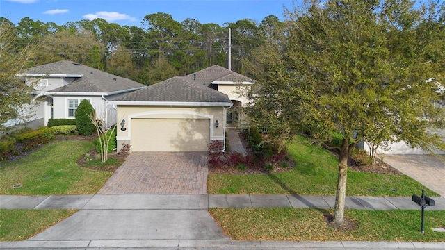 single story home featuring a garage, a shingled roof, decorative driveway, stucco siding, and a front yard