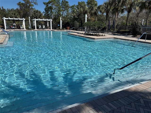 community pool featuring a patio area, fence, and a pergola