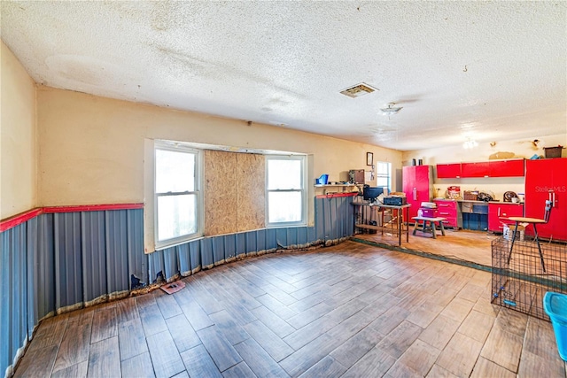 miscellaneous room with a textured ceiling and wood finished floors