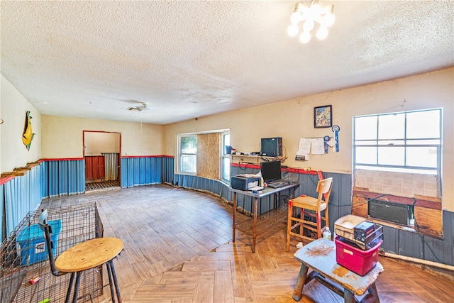 interior space with wainscoting and a textured ceiling