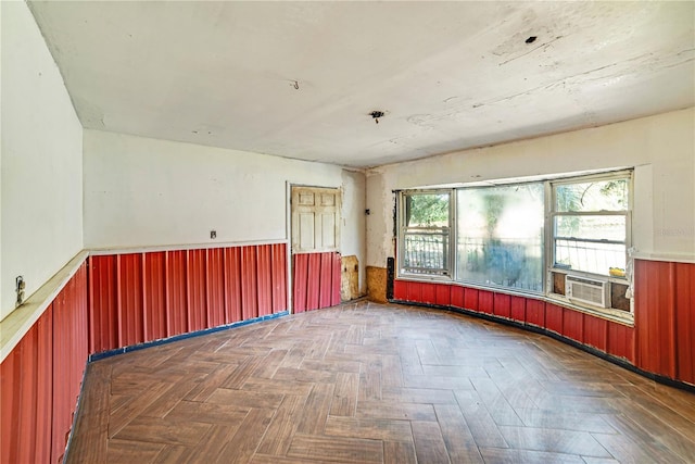 spare room featuring wood walls, wainscoting, and cooling unit