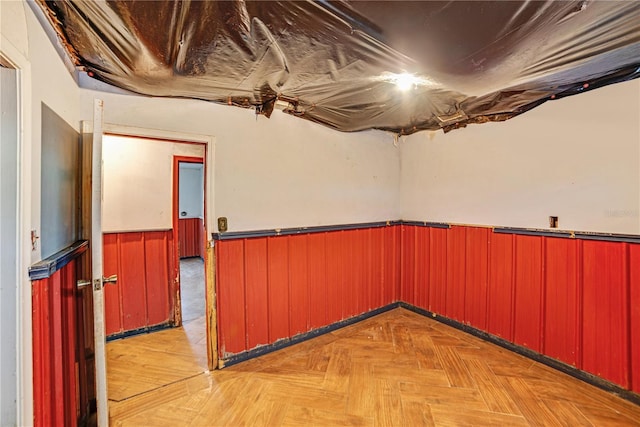 basement with a wainscoted wall and wood walls