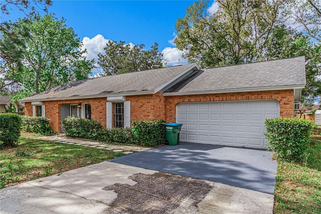 ranch-style home featuring a garage, driveway, brick siding, and a shingled roof