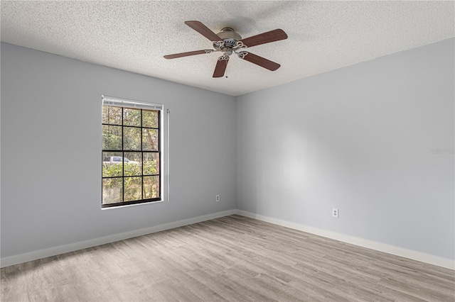 unfurnished room with a ceiling fan, a textured ceiling, baseboards, and wood finished floors