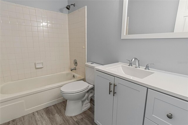 full bath featuring toilet, bathtub / shower combination, wood finished floors, and vanity