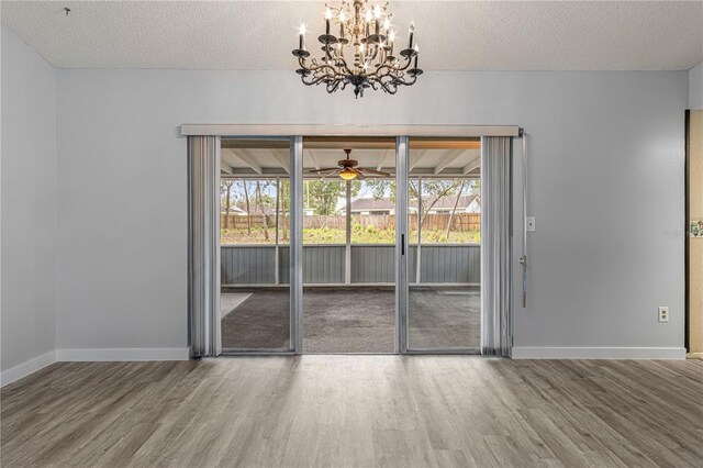 unfurnished dining area with a textured ceiling, a wealth of natural light, and wood finished floors