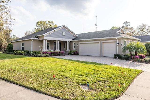 ranch-style house with an attached garage, decorative driveway, a front yard, a porch, and stucco siding