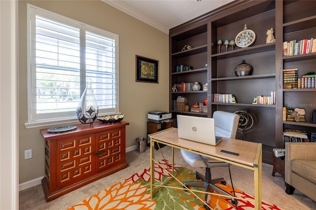 office area featuring built in shelves, baseboards, crown molding, and light colored carpet