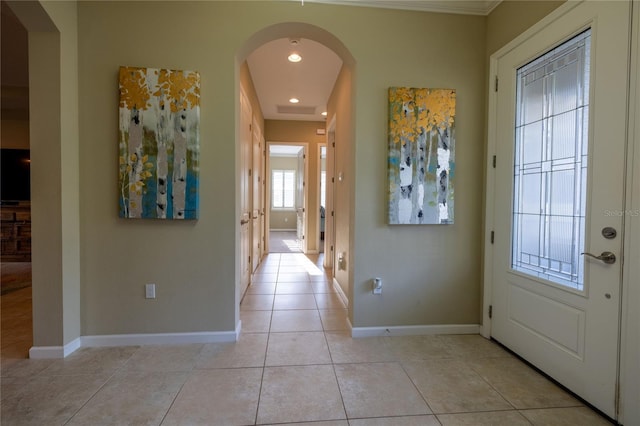 entryway with arched walkways, recessed lighting, light tile patterned flooring, and baseboards