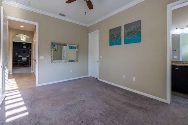 unfurnished bedroom featuring carpet, visible vents, crown molding, and baseboards