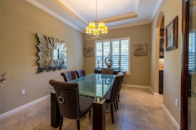 dining space with a chandelier, arched walkways, a raised ceiling, and ornamental molding