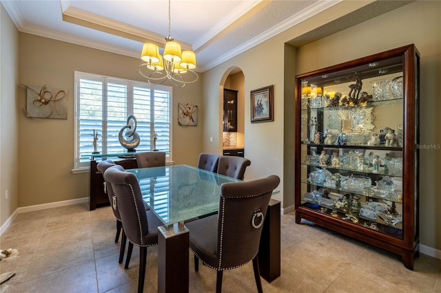 dining room featuring baseboards, a tray ceiling, arched walkways, and a notable chandelier