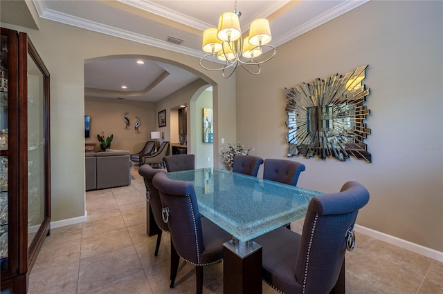 dining space with a tray ceiling, arched walkways, a chandelier, baseboards, and tile patterned floors