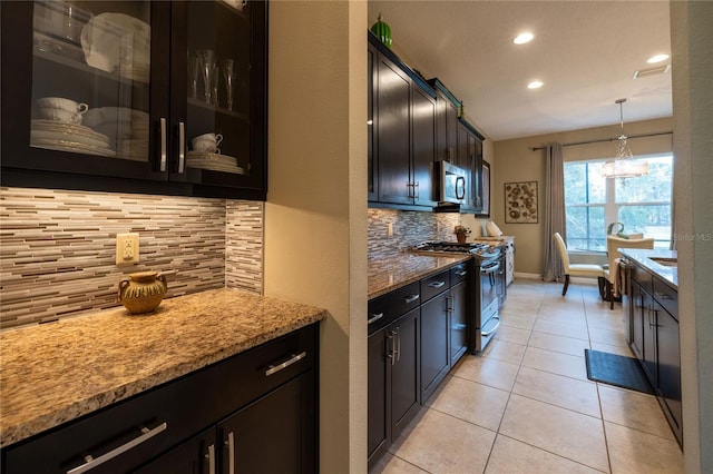 kitchen with pendant lighting, light tile patterned floors, decorative backsplash, appliances with stainless steel finishes, and light stone countertops