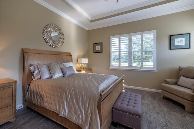 bedroom featuring baseboards, a tray ceiling, wood finished floors, and crown molding