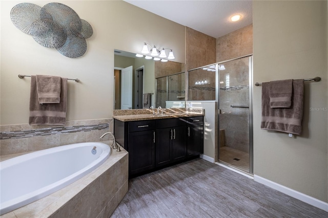 full bath featuring baseboards, wood finished floors, a garden tub, vanity, and a shower stall