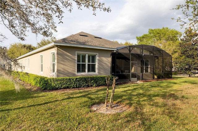 back of property featuring a lawn and stucco siding