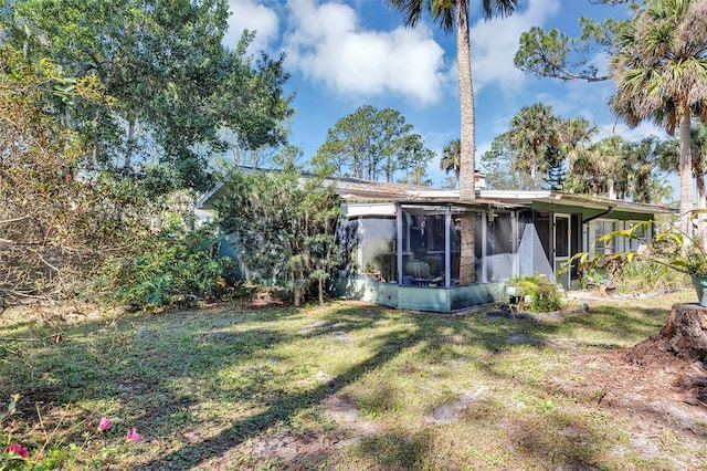 back of property featuring a yard and a sunroom