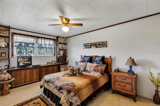 bedroom featuring light carpet, a ceiling fan, and crown molding