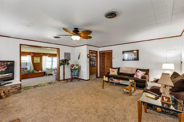 living area with ornamental molding, carpet, visible vents, and a ceiling fan