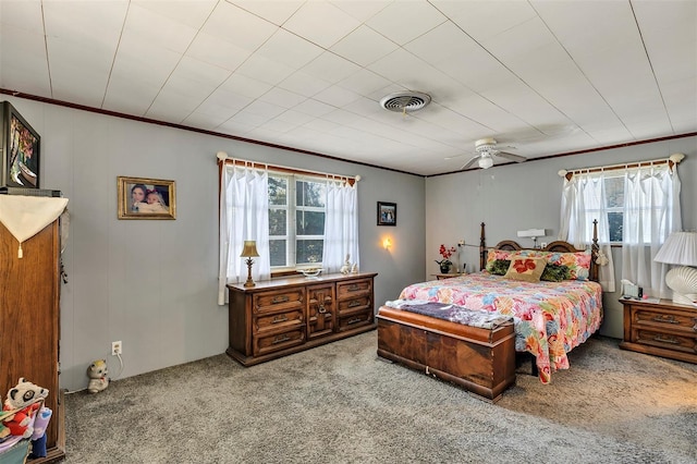 bedroom with a ceiling fan, visible vents, carpet flooring, and ornamental molding