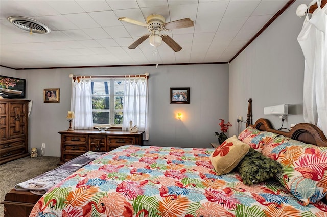 carpeted bedroom featuring a ceiling fan, visible vents, and crown molding