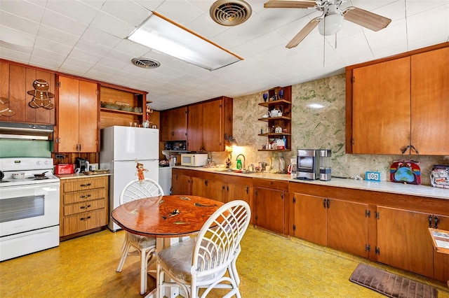 kitchen featuring white appliances, visible vents, light floors, under cabinet range hood, and open shelves