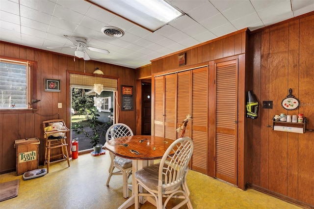 dining room featuring visible vents and wood walls