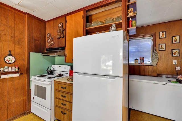 kitchen featuring wooden walls, under cabinet range hood, white appliances, light countertops, and brown cabinetry