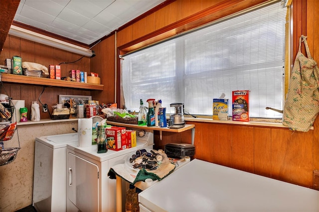 laundry room with laundry area, washing machine and dryer, a wealth of natural light, and wood walls