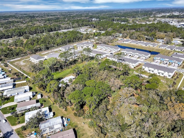 birds eye view of property featuring a wooded view and a residential view