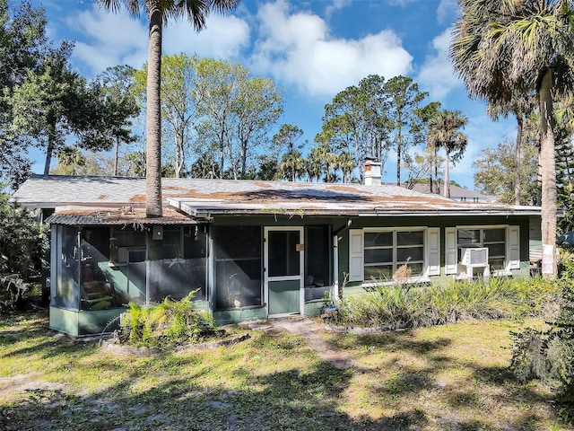 rear view of property with a sunroom and cooling unit