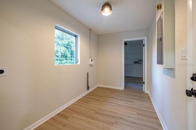 hall featuring light wood-type flooring and baseboards